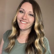 A woman with long hair and a necklace is smiling for the camera . A woman with long hair and a necklace is smiling for the camera .